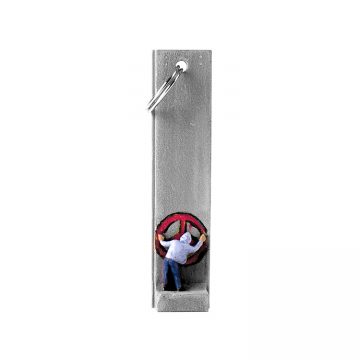 banksy walled off hotel key fob key chain with man in hoodie painting a red peace sign on section of wall