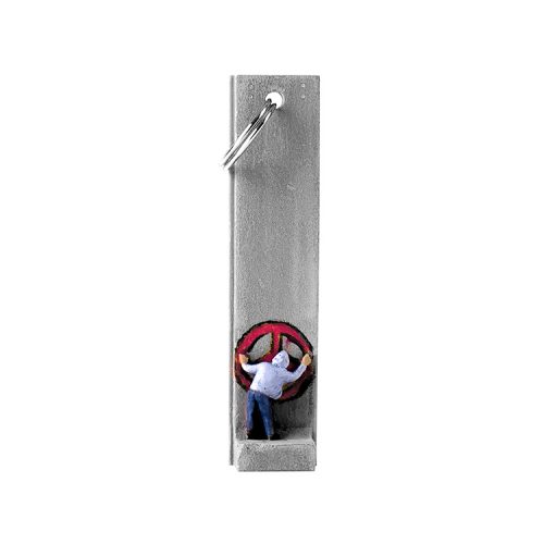 banksy walled off hotel key fob key chain with man in hoodie painting a red peace sign on section of wall