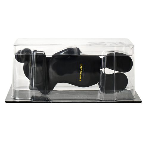 kaws holiday japan vinyl figure in black shown from behind with holiday japan stamp on back