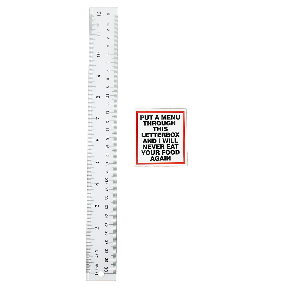 banksy menu sticker in clear frame next to ruler