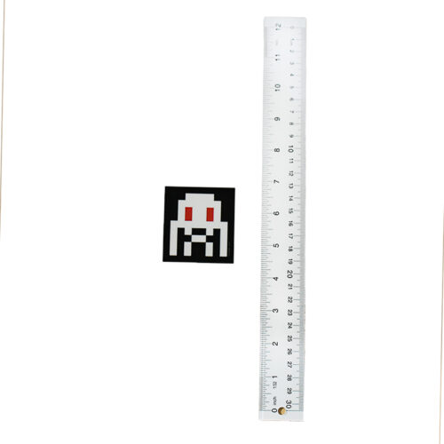 invader glow in the dark sticker next to ruler for scale