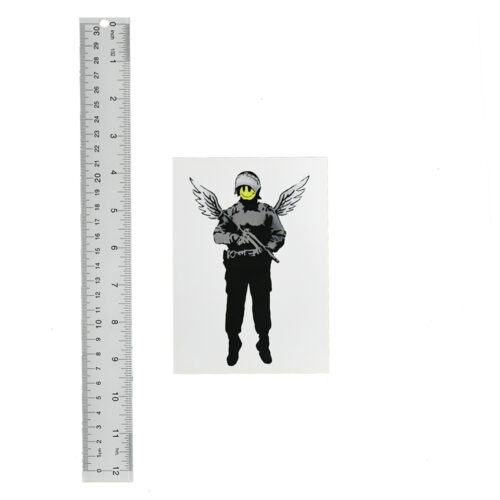 banksy angel cop flying copper showcard next to ruler
