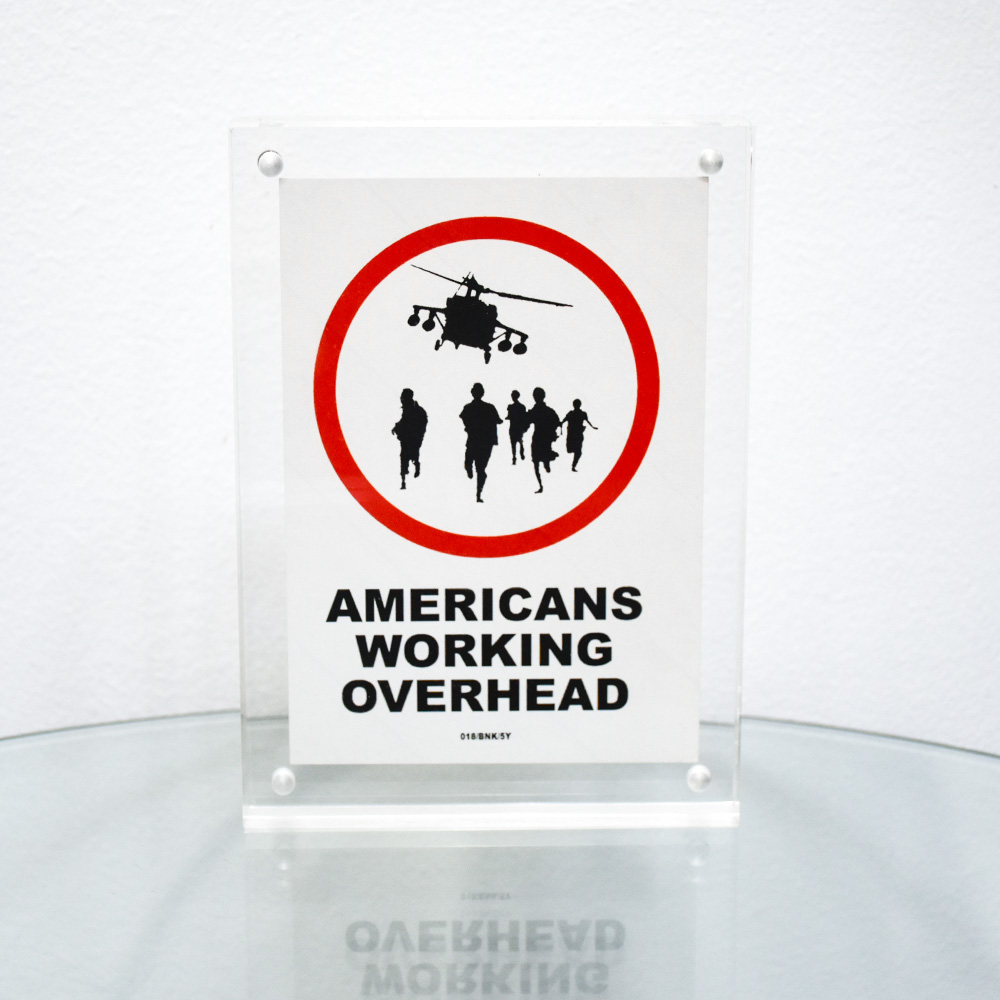 banksy americans working overhead sticker in frame framed on table