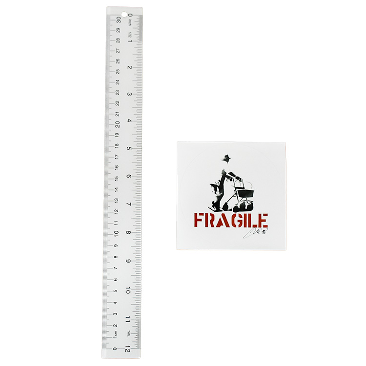 kunstrasen fragile signed sticker next to ruler for scale