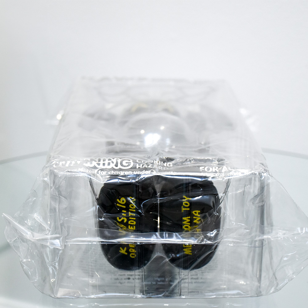 feet with printed text on kaws companion black in package