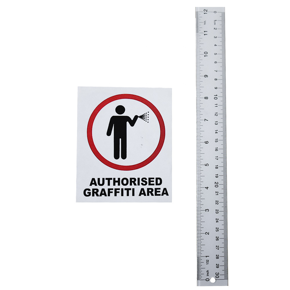 banksy authorised graffiti area sticker next to ruler for scale