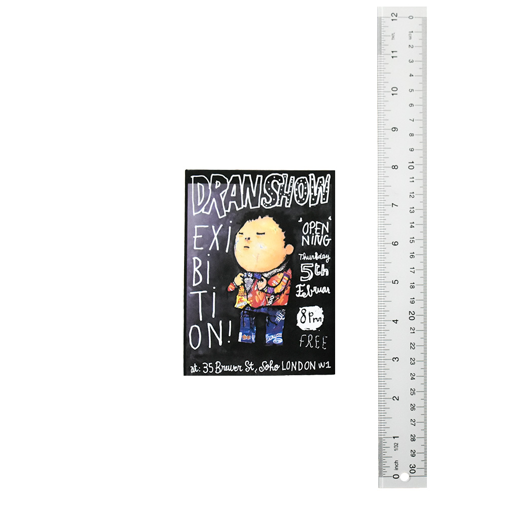 dran showcard from 2015 exhibition next to ruler for scale